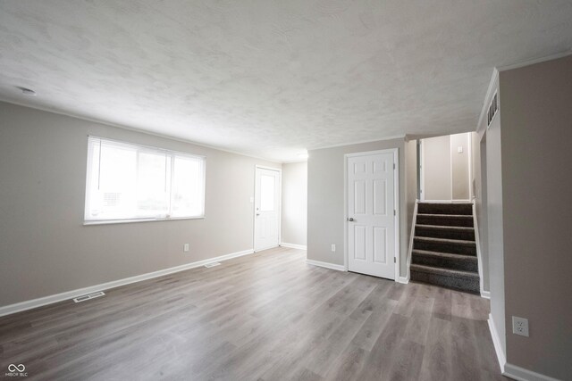 2740 Pawnee Dr, Indianapolis, IN 46229 - unfurnished living room with baseboards, stairs, wood finished floors, and a textured ceiling