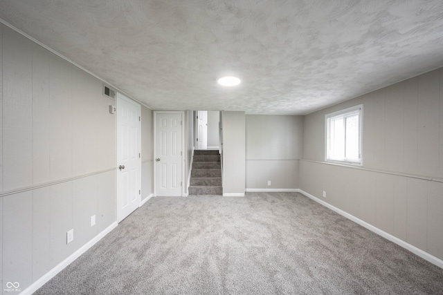 2740 Pawnee Dr, Indianapolis, IN 46229 - below grade area with stairs, baseboards, carpet flooring, and a textured ceiling