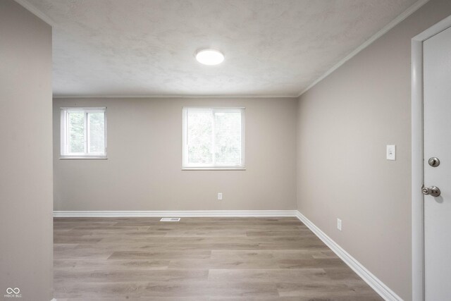 2740 Pawnee Dr, Indianapolis, IN 46229 - unfurnished room featuring crown molding, light wood finished floors, and baseboards