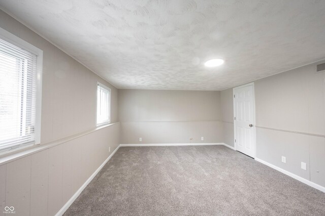2740 Pawnee Dr, Indianapolis, IN 46229 - carpeted empty room with baseboards and a textured ceiling