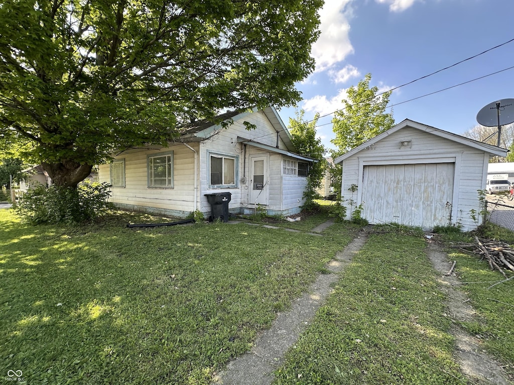 1830 Jefferson St, Anderson, IN 46016 - view of green lawn with a garage, driveway, and an outdoor structure