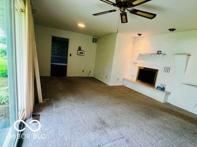 5141 Derome Dr, Fort Wayne, IN 46835 - unfurnished living room with healthy amount of natural light, carpet, ceiling fan, and a fireplace with raised hearth