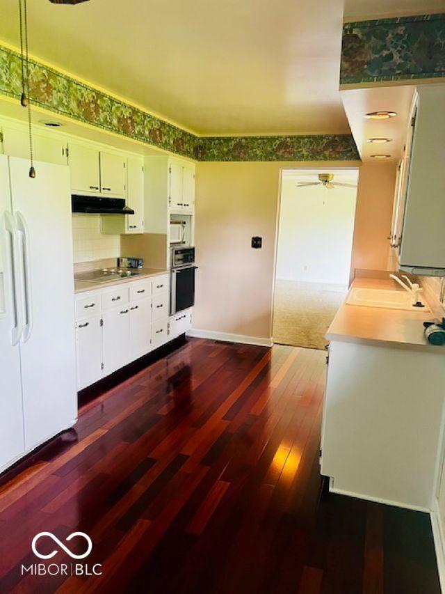 5141 Derome Dr, Fort Wayne, IN 46835 - kitchen featuring white fridge with ice dispenser, a sink, stainless steel oven, dark wood finished floors, and under cabinet range hood