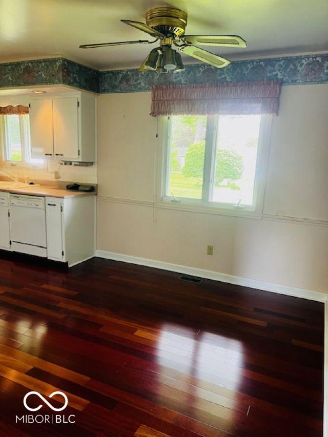 5141 Derome Dr, Fort Wayne, IN 46835 - kitchen with dishwasher, dark wood-type flooring, white cabinets, a ceiling fan, and baseboards