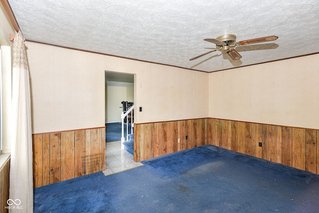 3325 Broadview Ct, Indianapolis, IN 46227 - carpeted empty room featuring wooden walls, a wainscoted wall, a ceiling fan, and ornamental molding