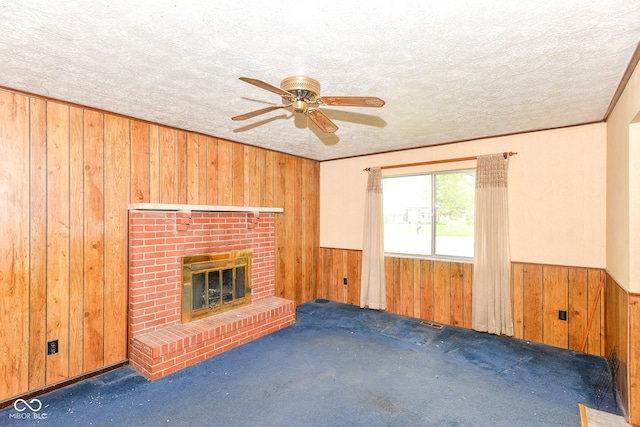 3325 Broadview Ct, Indianapolis, IN 46227 - unfurnished living room with wood walls, a fireplace, carpet, ceiling fan, and a textured ceiling