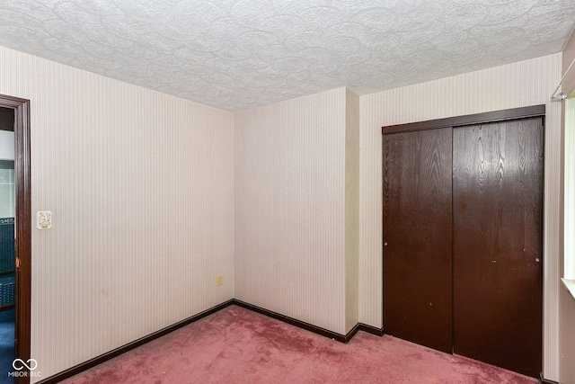 3325 Broadview Ct, Indianapolis, IN 46227 - unfurnished bedroom featuring carpet floors, a closet, a textured ceiling, baseboards, and wallpapered walls