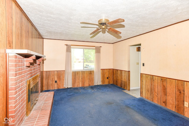 3325 Broadview Ct, Indianapolis, IN 46227 - spare room featuring wood walls, wainscoting, ceiling fan, a textured ceiling, and a fireplace