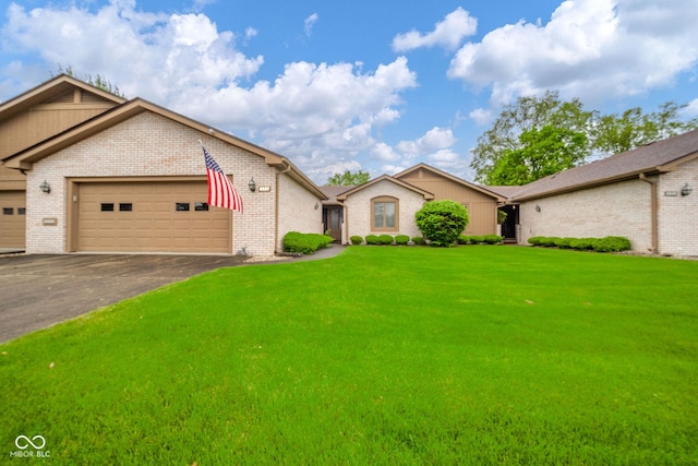 3537 Woodglen Way, Anderson, IN 46011 - view of front of house featuring an attached garage, asphalt driveway, a front yard, and brick siding