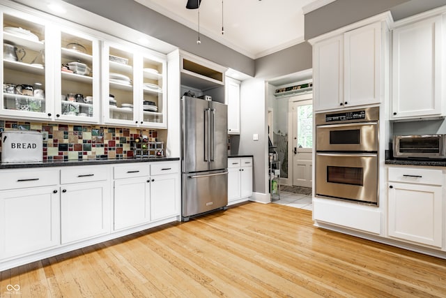 4130 N Meridian St, Indianapolis, IN 46208 - kitchen featuring stainless steel appliances, crown molding, white cabinetry, dark countertops, and light wood-style floors