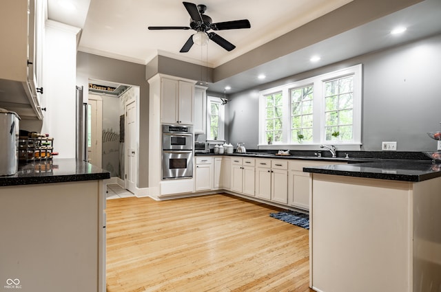 4130 N Meridian St, Indianapolis, IN 46208 - kitchen featuring double oven, crown molding, light wood-style flooring, white cabinets, and dark stone countertops