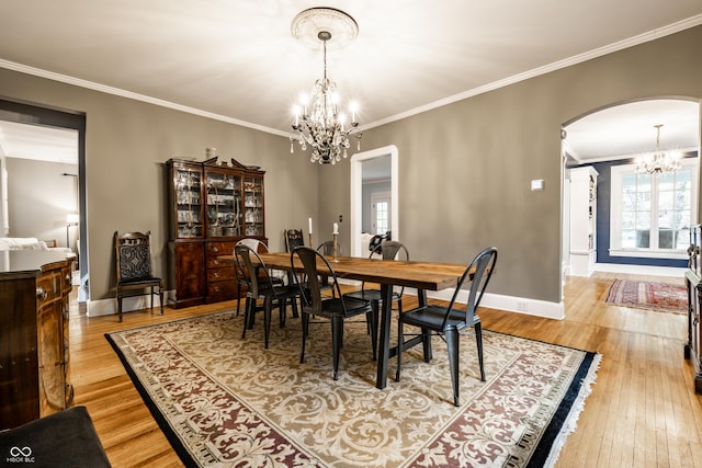 4130 N Meridian St, Indianapolis, IN 46208 - dining room featuring a chandelier, arched walkways, light wood finished floors, crown molding, and baseboards