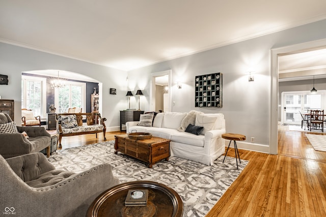 4130 N Meridian St, Indianapolis, IN 46208 - living room featuring a chandelier, ornamental molding, arched walkways, hardwood / wood-style floors, and baseboards