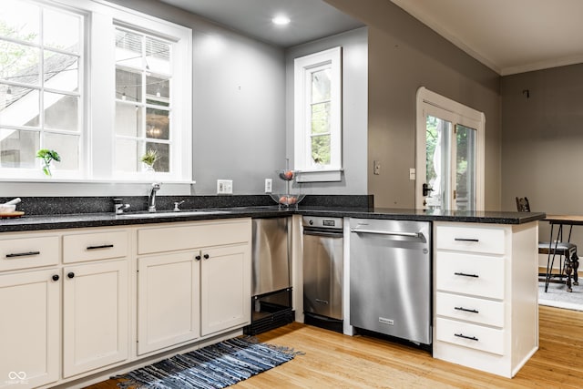 4130 N Meridian St, Indianapolis, IN 46208 - kitchen featuring stainless steel dishwasher, a sink, a peninsula, light wood-type flooring, and white cabinets