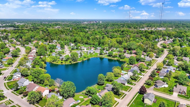 aerial view of residential area with a large body of water and a heavily wooded area