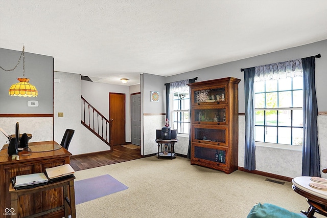 carpeted living area featuring stairway and baseboards