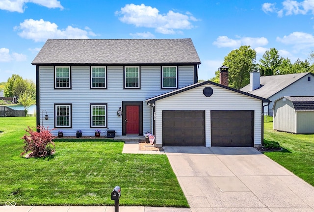 colonial house featuring a garage, a front lawn, concrete driveway, and a storage shed