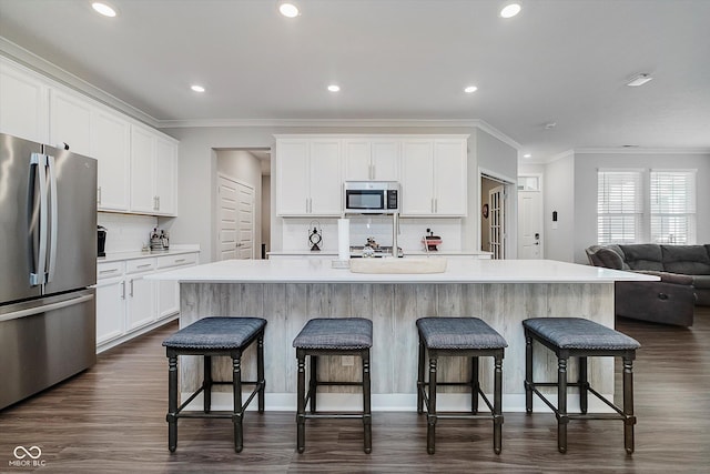5020 Eldon Dr, Noblesville, IN 46062 - kitchen featuring appliances with stainless steel finishes, crown molding, backsplash, recessed lighting, and dark wood-style floors