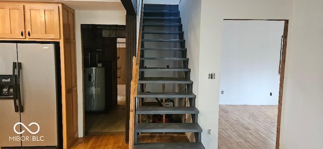 3854 Three Mile Rd, Centerville, IN 47330 - stairway with wood finished floors, water heater, and arched walkways