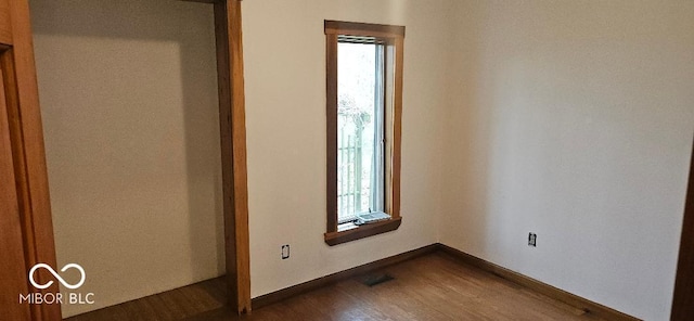 3854 Three Mile Rd, Centerville, IN 47330 - unfurnished bedroom with multiple windows, dark wood-style flooring, and baseboards