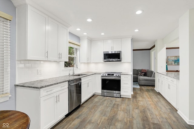 781 Dayton Dr, Carmel, IN 46033 - kitchen with stainless steel appliances, a sink, wood finished floors, light stone counters, and white cabinets