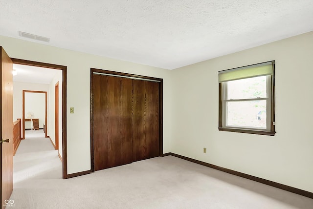 781 Dayton Dr, Carmel, IN 46033 - unfurnished bedroom with light carpet, baseboards, a closet, and a textured ceiling