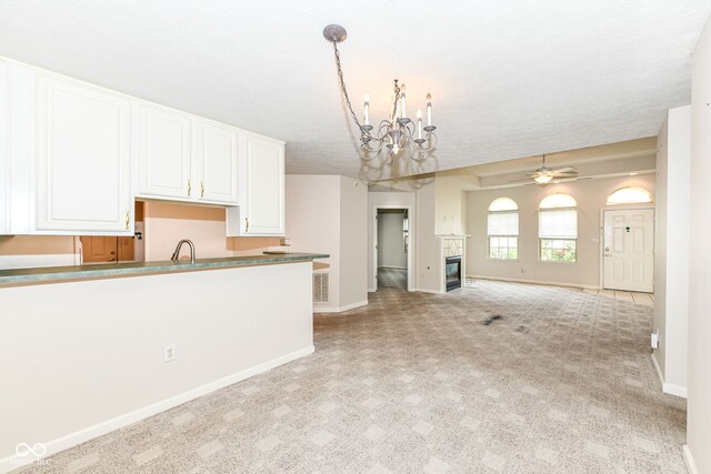 7645 Briarstone Ln, Indianapolis, IN 46227 - kitchen with open floor plan, light colored carpet, a chandelier, white cabinets, and a textured ceiling