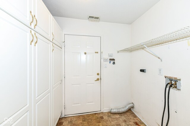 7645 Briarstone Ln, Indianapolis, IN 46227 - laundry room with cabinet space, hookup for an electric dryer, and stone finish flooring