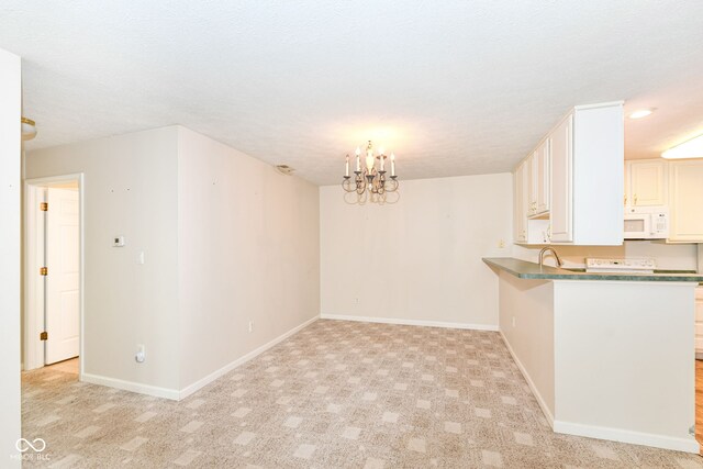 7645 Briarstone Ln, Indianapolis, IN 46227 - kitchen featuring white microwave, a peninsula, a chandelier, light colored carpet, and a breakfast bar