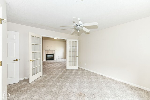 7645 Briarstone Ln, Indianapolis, IN 46227 - unfurnished room featuring french doors, carpet flooring, a ceiling fan, and a tile fireplace