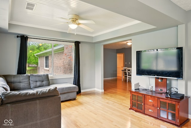 6462 Wings Ct, Brownsburg, IN 46112 - living room featuring a tray ceiling, light wood-type flooring, ceiling fan, baseboards, and ornamental molding