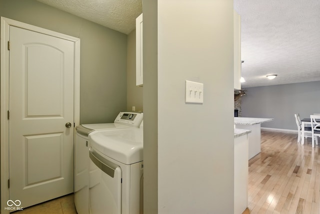 6462 Wings Ct, Brownsburg, IN 46112 - laundry area with a textured ceiling, washer and clothes dryer, light wood finished floors, a fireplace, and baseboards