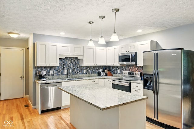 6462 Wings Ct, Brownsburg, IN 46112 - kitchen with stainless steel appliances, a sink, a textured ceiling, backsplash, and light wood-style floors