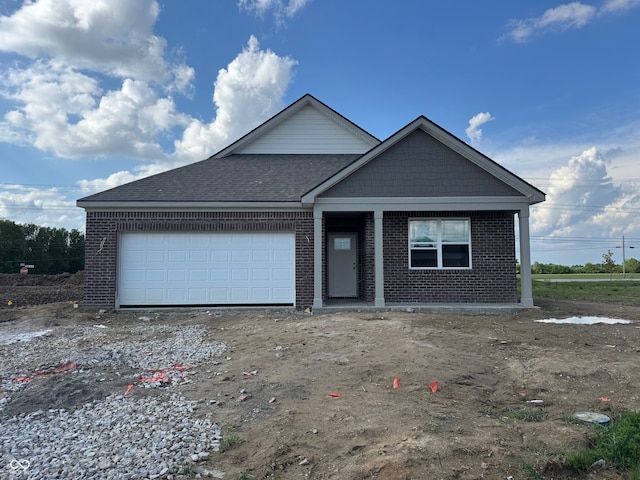 view of front of home featuring brick siding, an attached garage, and roof with shingles
