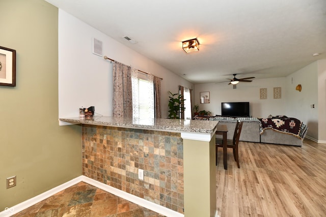 7604 Cloudy Ct, Camby, IN 46113 - kitchen featuring a ceiling fan, baseboards, light stone countertops, a peninsula, and light wood finished floors