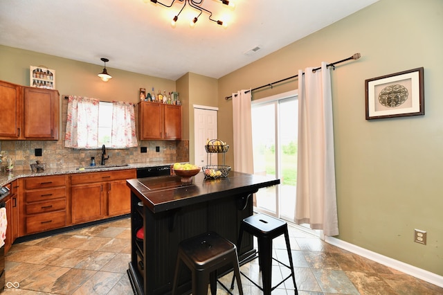 7604 Cloudy Ct, Camby, IN 46113 - kitchen with a sink, brown cabinetry, backsplash, stone tile floors, and baseboards
