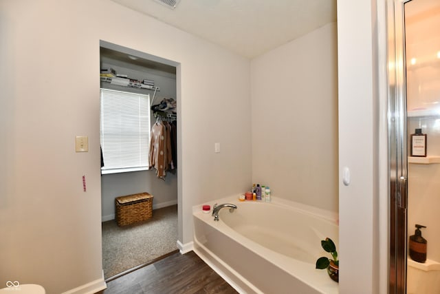 7604 Cloudy Ct, Camby, IN 46113 - bathroom featuring a bath, wood finished floors, and baseboards