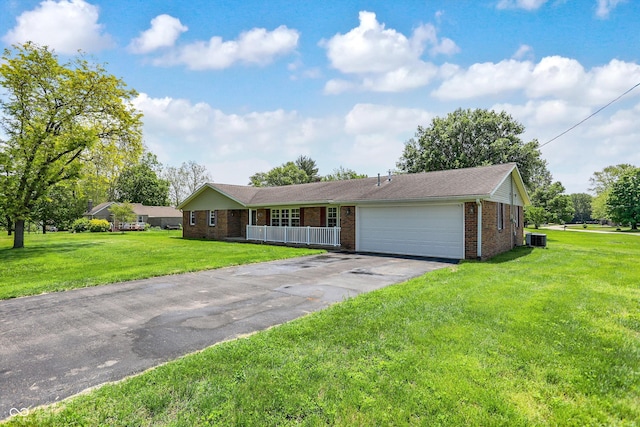 ranch-style house with brick siding, driveway, an attached garage, a front lawn, and central AC