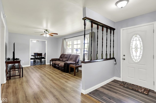 foyer featuring wood finished floors, a ceiling fan, and baseboards