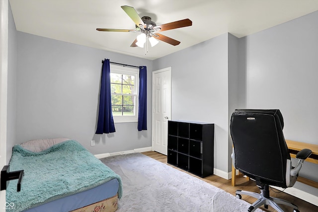 bedroom with a desk, baseboards, ceiling fan, and wood finished floors