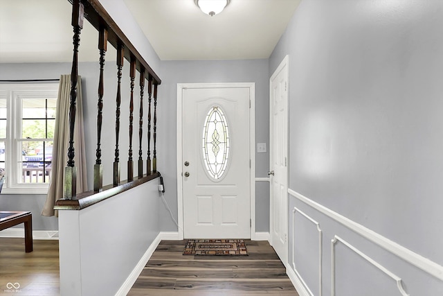 foyer with dark wood-style flooring and baseboards