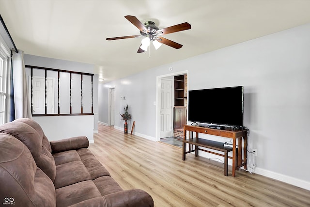 living area with ceiling fan, light wood-style flooring, and baseboards