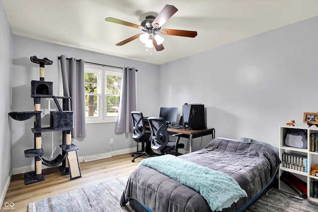bedroom with wood finished floors, baseboards, and ceiling fan