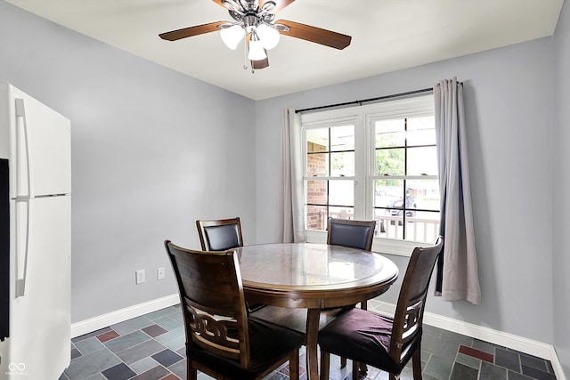 dining space with baseboards and a ceiling fan