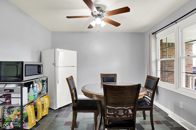 dining room with ceiling fan and baseboards