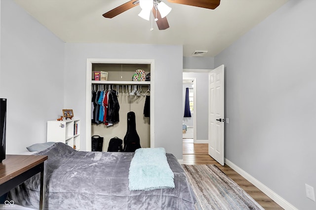 bedroom featuring wood finished floors, a closet, baseboards, and a ceiling fan