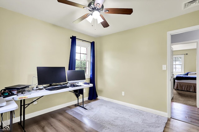 office area featuring a ceiling fan, wood finished floors, and baseboards