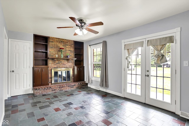 unfurnished living room featuring built in features, baseboards, ceiling fan, french doors, and a brick fireplace