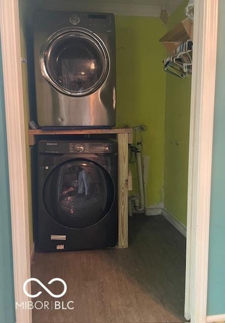 5802 Bertha St, Indianapolis, IN 46241 - laundry room featuring stacked washer / dryer, wood finished floors, and ornamental molding