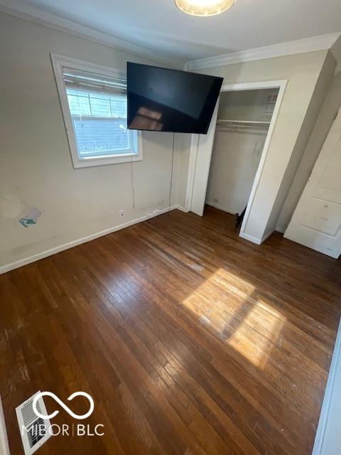 5802 Bertha St, Indianapolis, IN 46241 - unfurnished bedroom with wood finished floors, crown molding, a closet, and baseboards